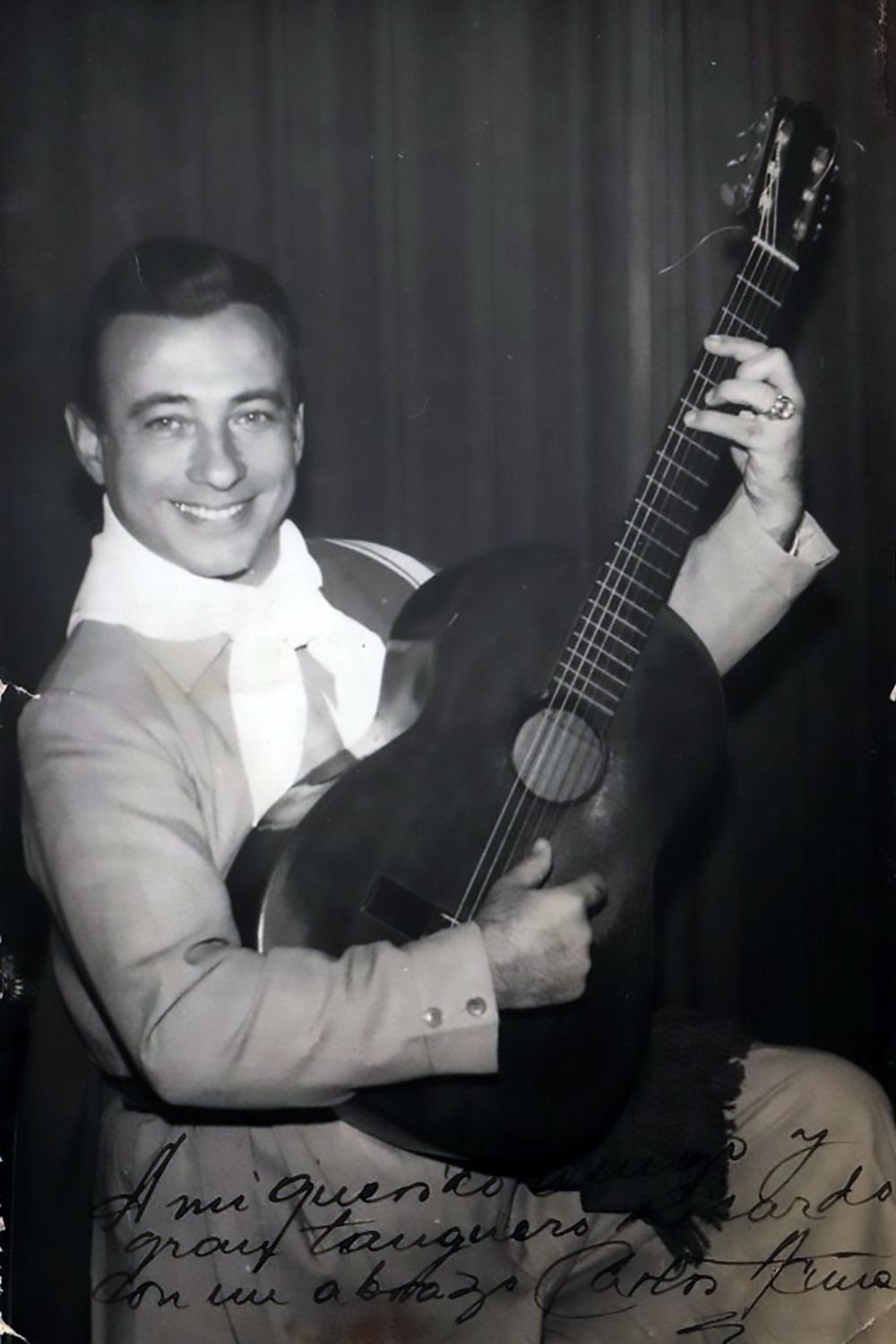 Carlos Acuña tocando guitarra, cantor y compositor de tangos.