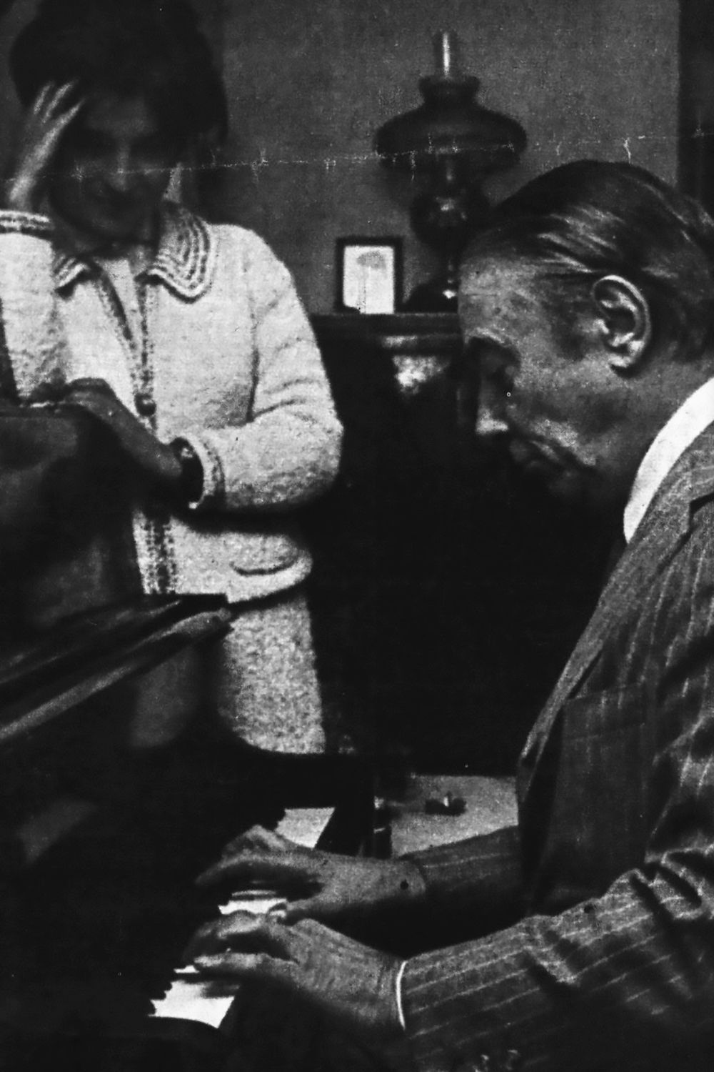 Enrique Cadícamo tocando el piano, con su esposa, Nelly. Foto blanco y negro.
