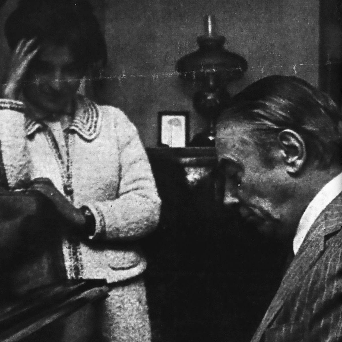 Enrique Cadícamo tocando el piano, con su esposa, Nelly. Foto blanco y negro.
